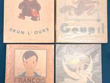 four children ' s books are sitting on a blue cloth