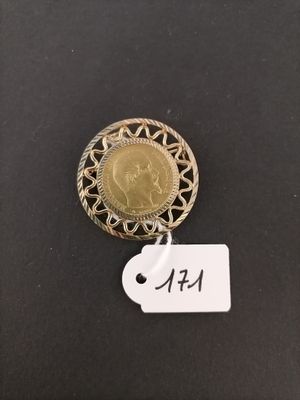 a gold coin with a tag attached to it on a black surface