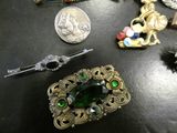 a lot of jewelry on a table next to a coin