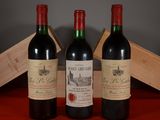 three bottles of red wine sitting next to a wooden box