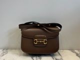 a brown leather bag with a gold buckle on the front