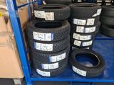 many tires stacked on a blue cart in a warehouse