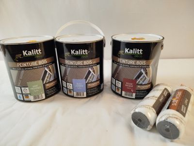trois pots de peinture et deux pots de peinture posés sur une surface blanche