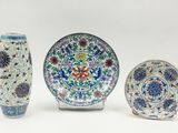 three pieces of chinese pottery are displayed on a white surface
