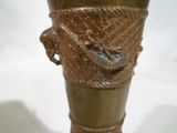 un vase en bronze orné d'un oiseau, posé sur une table