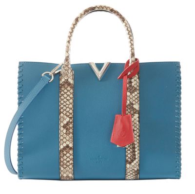 a blue and brown handbag with a red handle