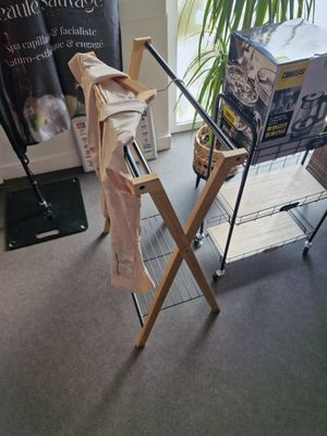 un portant avec des vêtements, près d'une fenêtre