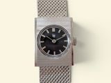 a silver watch with a black face on a white background