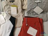 three pairs of pants and a sweater on a table