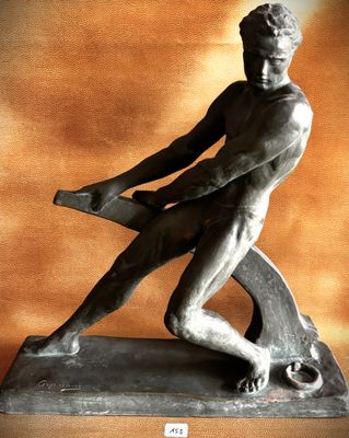 statue of a man holding a hammer on a base against a wall