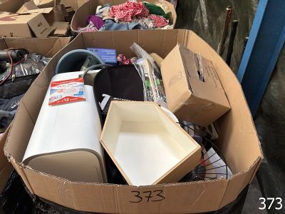 une boîte en carton remplie d'objets divers, posée dans la rue