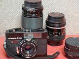 many cameras and lenses on a table with a red table cloth