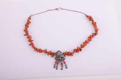 a necklace with coral and silver beads on a white background