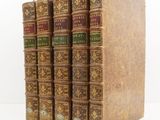trois livres sont empilés sur une surface blanche