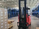 a forklift in a large warehouse with boxes on the floor
