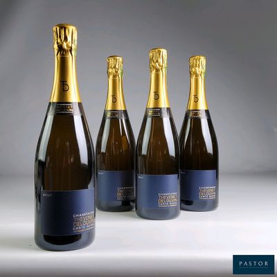 four bottles of champagne are lined up on a table