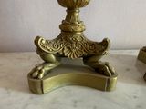 a gold candle holder sitting on top of a marble table