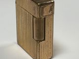 un briquet doré posé sur une surface blanche
