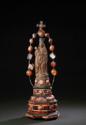 a statue of a woman holding a rosary and surrounded by orange beads