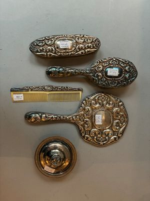 trois cuillères en argent, un peigne et un peigne posé sur une table