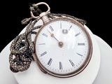 a white plate with a gold pocket watch on it