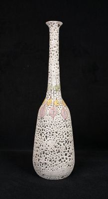 a white vase with a pink and yellow design on it
