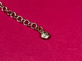 a close up of a necklace on a pink surface