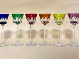 plusieurs verres à vin de couleurs différentes sont alignés