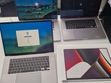 three laptops are sitting on a table with a mouse and a keyboard