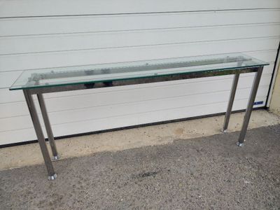 a glass table with a metal frame and a glass top