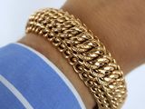 a close up of a person ' s arm wearing a gold chain bracelet