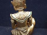 two gold statues of people sitting on a blue surface