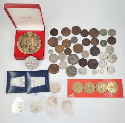 an assortment of silver and bronze coins including a clock and a red box