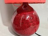 a red table lamp with a red shade on it