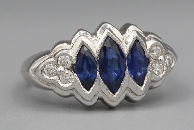 Bague en or gris ornée de trois saphirs navettes épaulés de brillants. - Photo 1