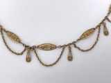 a gold necklace with dangling drops of water on a chain