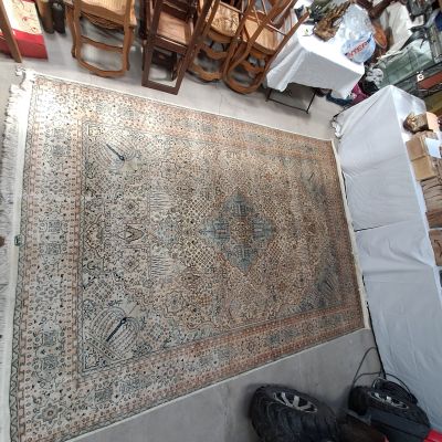 un grand tapis posé à même le sol dans une pièce où se trouvent de nombreuses chaises