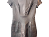 robe en cuir gris suspendue à un cintre sur fond blanc