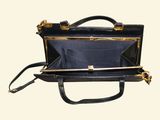 a black and gold purse with a handle on a white background