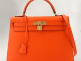 sac à main Hermès en cuir orange avec des finitions dorées