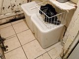 une salle de bains sale avec des toilettes et une poubelle à l'intérieur