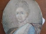 an old picture of a woman in a blue dress on a wooden table