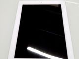 un iPad posé sur une table blanche, dont l'écran est noir