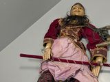a statue of a man laying on the floor with a sword