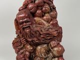deux figurines chinoises sculptées représentant des singes sur un tas de crânes