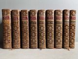 six vieux livres alignés sur une table