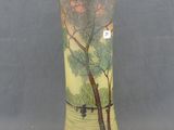 a vase with a painting on it sitting on a table