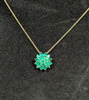 une femme portant un collier orné d'une fleur verte