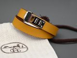 un gros plan sur un bracelet en cuir jaune muni d'une boucle en argent