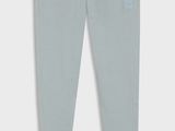 une photo d'un pantalon de survêtement gris pour petit garçon, avec un petit patch sur le côté